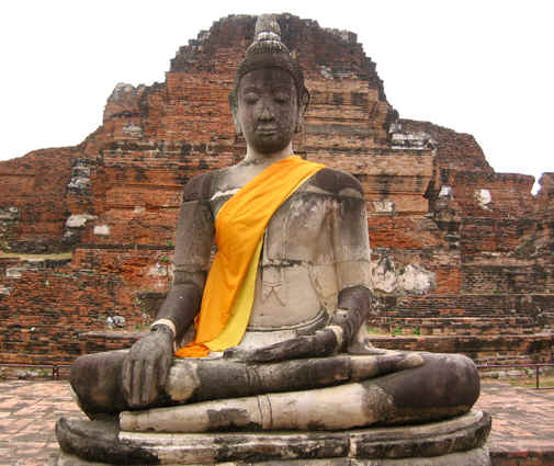 This statue remains whole, draped in orange/gold cloth by devotees, Ayutthaya, Thailand