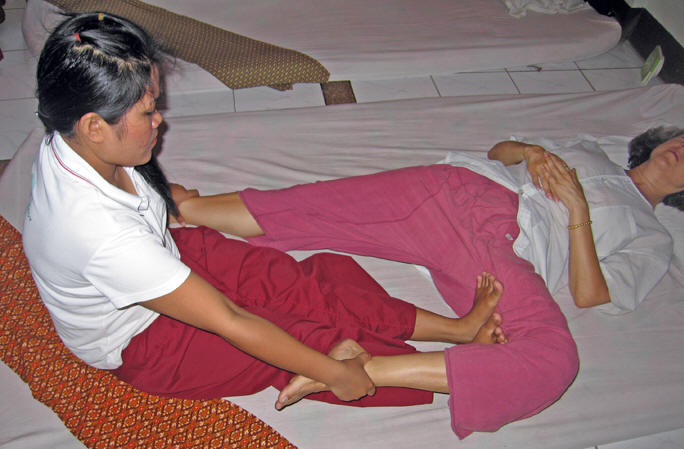 Stretching and pulling Akaisha's thighs. Chiang Mai, Thailand