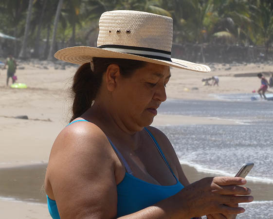 Woman texting while at the beach, Chacala, Mexico