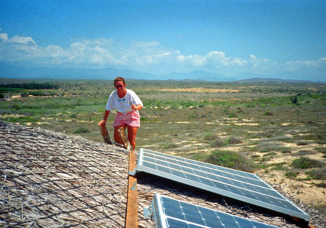 Suzanne O'Rourke installing solar panels on a Palapa in Todos Santos, Mexico