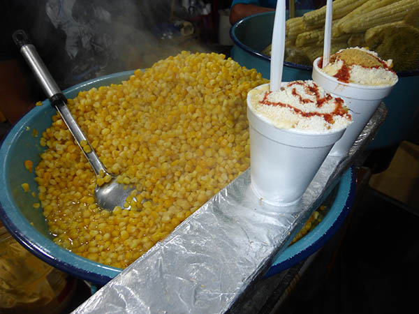 Tubs of corn, and corn in cups with salsa, spices and grated cheese