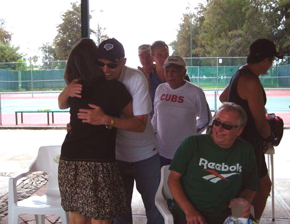 All the male tennis players standing in line to give Akaisha a hug on her birthday. Chapala tennis courts, Mexico