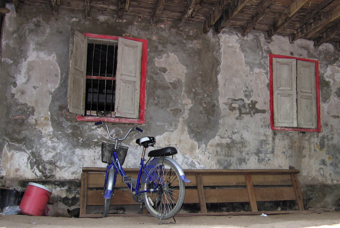 bicycle in front of aging wall, with windows