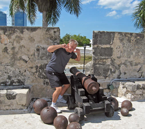 Old rusty cannons and cannon balls of differing sizes