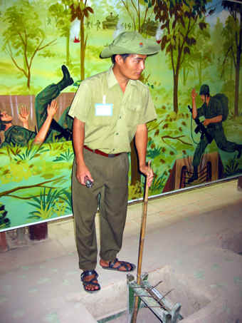 GUIDE WEARING VC SANDALS DEMONSTRATING ONE OF MANY TYPES OF BOOBY TRAPS