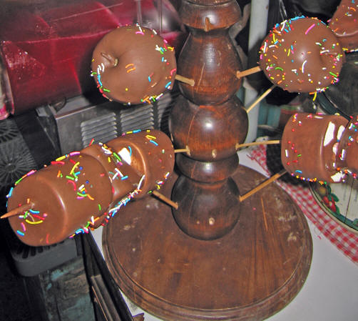 Apples and marshmallows dipped in chocolate for sale.