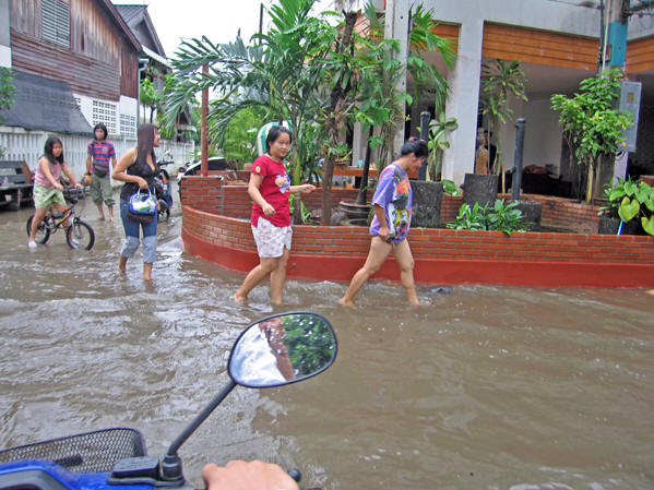 These Thai women are keeping their positive frame of minds while walking in the flood waters, Chaing Mai, Thailand