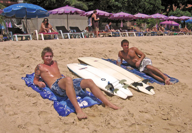 Young men resting between waves at Kata Beach, Thailand