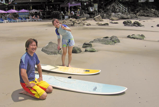 Surfing couple on the beach getting their boards ready. Kata Beach, Thailand